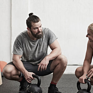 Personal Trainer At Work With Client