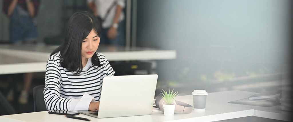 Lady At Her Desk On Her Laptop Computer