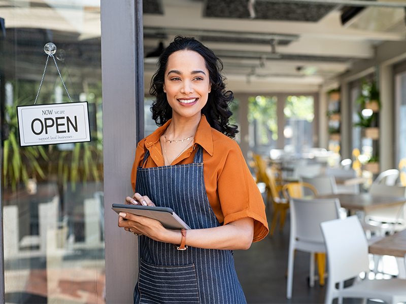 Small Business Person Out Front With Open Sign