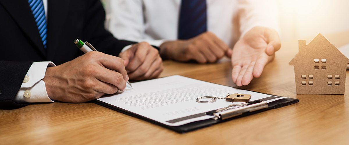 Two People Signing A Real Estate Contract