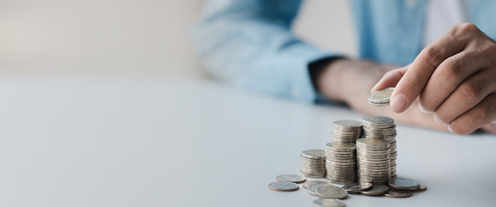 Man Adds To Coins on a table