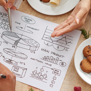 Table With Business Plans And Cookies